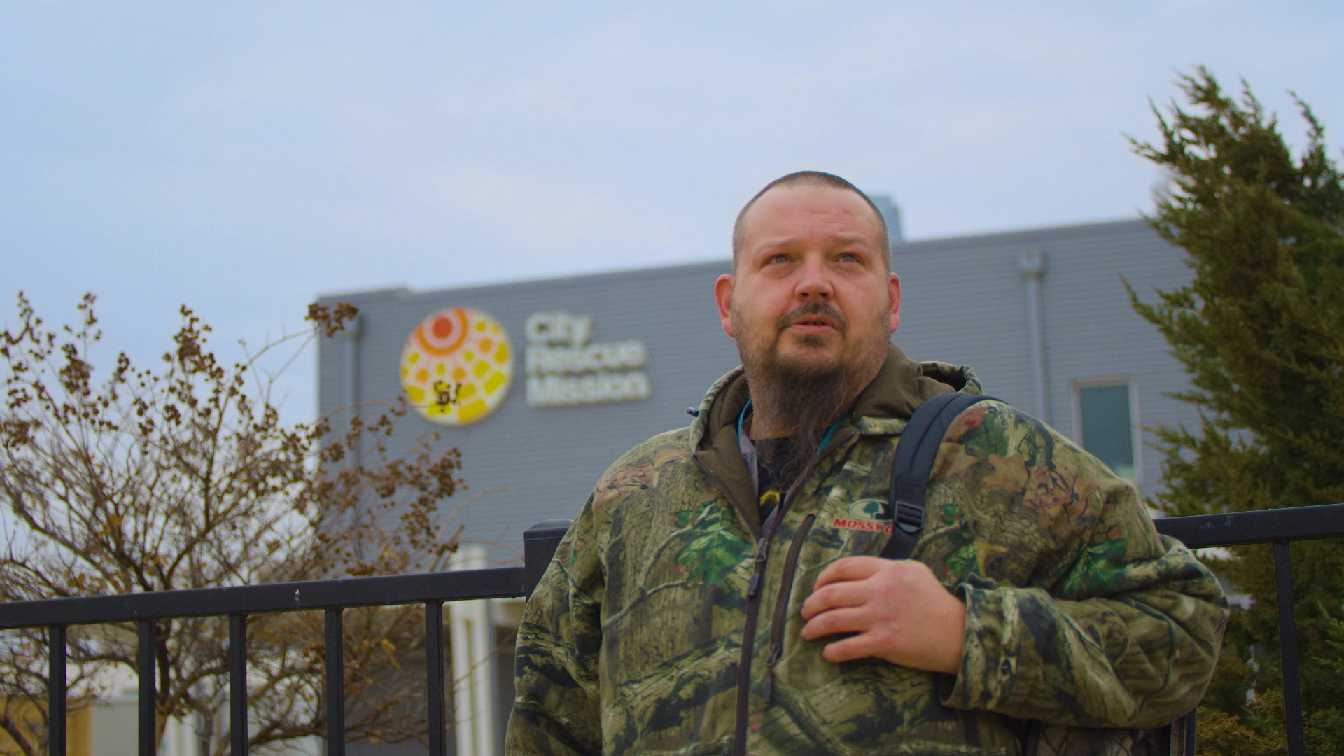 Unhoused man standing with backpack